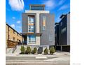 Striking townhouse featuring gray wood and brick facade, well-maintained landscaping and rooftop deck at 2625 W 25Th Ave # 7, Denver, CO 80211