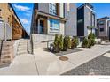 Modern townhouse featuring gray wood and brick facade with landscaping and convenient ramp access at 2625 W 25Th Ave # 7, Denver, CO 80211
