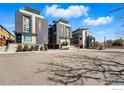 Modern townhouses featuring gray wood and brick facade, landscaping, rooftop decks along quiet street at 2625 W 25Th Ave # 7, Denver, CO 80211