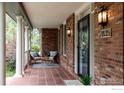 Charming brick front porch with seating area and tiled floor, perfect for enjoying the outdoors at 2835 Links Dr, Boulder, CO 80301