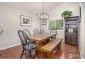 Formal dining room with a rustic wooden table and a stylish chandelier at 2935 Bow Line Pl, Longmont, CO 80503