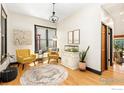 Bright living room with hardwood floors, cheerful yellow accent chairs, and a modern chandelier at 300 E Cleveland St, Lafayette, CO 80026