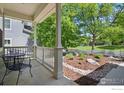 Covered front porch with seating area, offering views of the landscaped yard and picket fence at 3093 Red Deer Trl, Lafayette, CO 80026