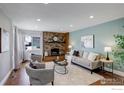 Comfortable living room with a decorative fireplace, hardwood floors, and neutral-toned furnishings at 319 Carter Ln, Longmont, CO 80501