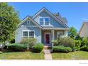 Inviting two-story home with light blue siding, a red front door and manicured landscaping enhance its curb appeal at 4218 San Marco Dr, Longmont, CO 80503