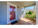 Cozy covered front porch featuring a welcome mat, stylish door, and ample space for relaxing and enjoying the outdoors at 4218 San Marco Dr, Longmont, CO 80503