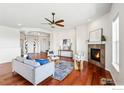 Bright living room featuring a fireplace, wood floors, and an eye-catching ceiling fan at 4648 Belford Cir, Broomfield, CO 80023