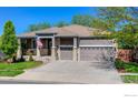 Charming ranch-style home featuring a manicured lawn, three-car garage, and covered front porch at 489 Hayloft Way, Brighton, CO 80601