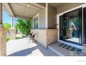 Inviting covered front porch with seating area and view of the landscaped front yard at 489 Hayloft Way, Brighton, CO 80601