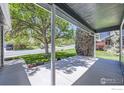 Spacious front porch offers an inviting view of the neighborhood street and mature trees at 5491 E 117Th Ave, Thornton, CO 80233
