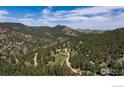 Scenic aerial view of a mountain community, showcasing winding roads and lush forest landscape at 604 Bow Mountain Rd, Boulder, CO 80304