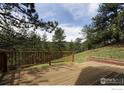 Expansive wooden deck with railing offers a serene outdoor space surrounded by mature trees at 604 Bow Mountain Rd, Boulder, CO 80304