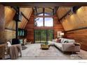 Inviting living room with vaulted wood ceilings, a wood burning stove, and a comfortable sectional sofa at 604 Bow Mountain Rd, Boulder, CO 80304