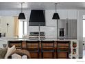 Modern kitchen with a breakfast bar, stainless steel appliances and white subway tile backsplash at 7204 Rustic Trl, Boulder, CO 80301