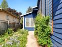 Charming blue home with lush garden pathway featuring a beautiful fenced yard at 821 Hayden Ct, Longmont, CO 80503