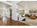 Bright living room featuring hardwood floors, plush carpet, and an arched entryway at 860 Quintana Ln, Erie, CO 80516