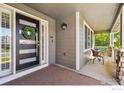 Inviting covered front porch with a decorative wreath and outdoor seating area at 860 Quintana Ln, Erie, CO 80516