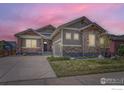 Charming single-Gathering home with stone accents and a well-manicured front yard and a concrete driveway at 874 Quarry Cir, Erie, CO 80516