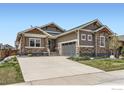 Charming single-Gathering home with stone accents and a well-manicured front yard and a concrete driveway at 874 Quarry Cir, Erie, CO 80516