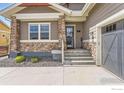 Inviting home exterior with stone accents, a well-maintained lawn, and an attached garage with concrete driveway at 874 Quarry Cir, Erie, CO 80516