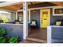 Close-up of front porch with seating, a yellow door, and stylish details at 908 Rex St, Louisville, CO 80027