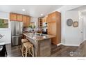 Kitchen with stainless steel appliances, island with sink, and wooden cabinets at 9306 Ingalls St, Westminster, CO 80031