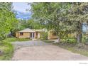 Exterior view of a well-maintained single-story home with a gravel driveway and mature trees at 1047 Cherryvale Rd, Boulder, CO 80303