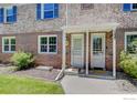 Close up of the entrance to a brick townhome featuring covered porch, and blue shutters at 1235 Leyden St, Denver, CO 80220