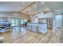 Open-concept living room and kitchen with wood floors, stainless steel appliances and bright, modern décor at 1237 Cornell Dr, Longmont, CO 80503