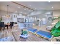 Spacious open-concept living area with breakfast bar seating, dining table, and comfortable lounging furniture at 1237 Cornell Dr, Longmont, CO 80503