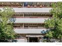 Close-up of apartment building highlighting balconies, entrance awning, and surrounding greenery at 1441 N Humboldt St # 302, Denver, CO 80218