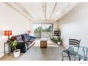Bright living room featuring exposed concrete beams, a sliding glass door to the balcony, and stylish furnishings at 1441 N Humboldt St # 302, Denver, CO 80218