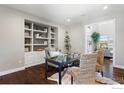 Bright home office features built-in shelving, a glass top desk and two comfortable woven chairs at 16069 Pikes Peak Dr, Broomfield, CO 80023