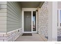 Inviting front entry features a gray door, sidelight window, and stone accents at 16860 Mckay Dr, Mead, CO 80542