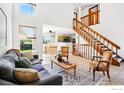 Bright living room with high ceilings, tile floors, and staircase at 1817 Juniper St, Longmont, CO 80501