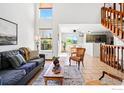 Bright and inviting living room featuring tile floors, stairs, and a view into the dining area at 1817 Juniper St, Longmont, CO 80501