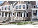 Attractive two-story townhome with a covered front porch, landscaped front, and neutral siding at 197 Liberty St, Erie, CO 80516
