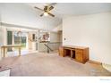 Open living area featuring carpet floors, vaulted ceiling, desk, and adjacent breakfast nook and kitchen at 2167 Hackberry Cir, Longmont, CO 80501