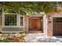 Welcoming front entrance with a beautiful wooden door, brick accents, and manicured landscaping at 2345 Spotswood Pl, Boulder, CO 80304