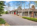Attractive home showcasing mature landscaping, a paved driveway, and unique architectural features at 32399 Woodland Dr, Evergreen, CO 80439