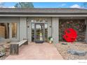 Inviting home entrance with unique stone accents, modern door, and an eye-catching red sculpture at 32399 Woodland Dr, Evergreen, CO 80439
