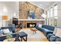 Cozy living room with stone fireplace, hardwood floors, and ample natural light from large windows at 32399 Woodland Dr, Evergreen, CO 80439
