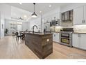 Modern kitchen with stainless steel appliances, white cabinets, and a wood-clad island at 3301 Arapahoe Ave # 106, Boulder, CO 80303