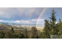 Expansive view overlooking mountain landscape featuring double rainbow and lush green forests at 33090 Janelle Cir, Golden, CO 80403