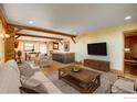 Inviting living room boasts hardwood floors, exposed beams, and a cozy fireplace for a warm, rustic atmosphere at 33090 Janelle Cir, Golden, CO 80403