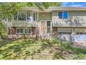 Split level home with bay window and brick accents surrounded by lush green landscaping at 4350 Butler Cir, Boulder, CO 80305