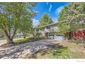 Suburban home with mature trees, long driveway, and a classic two-car garage at 4350 Butler Cir, Boulder, CO 80305