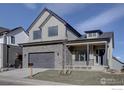 Inviting two-story home with stone accents, a well-manicured lawn, and an attached garage at 470 Muirfield Cir, Louisville, CO 80027