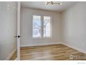 Minimalist bedroom with hardwood floors, large windows, and contemporary lighting fixture at 497 Muirfield Cir, Louisville, CO 80027