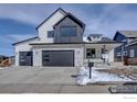 Striking two-story home with stone accents, a three-car garage, and modern design elements at 497 Muirfield Cir, Louisville, CO 80027